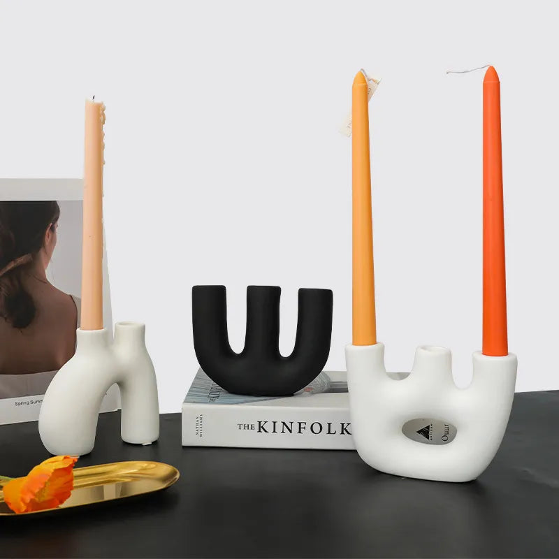 Reese Candle Holder collection - A modern display of ceramic candle holders in organic shapes, available in black and white colorways. The cool rounded shapes create a visually appealing design with four different variations. Elevate your space with these contemporary candle holders for a stylish and unique touch.