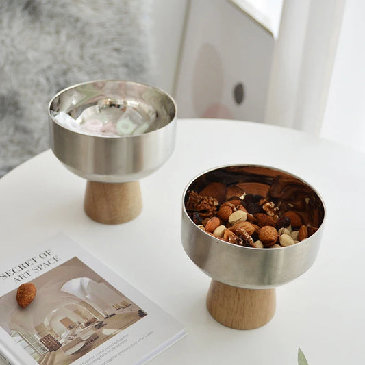 Eddard Serving Bowl featuring a modern design with a sleek stainless steel bowl and a sturdy wooden base. Compact and stylish, this small serving bowl is perfect for home decor enthusiasts looking to add a chic touch to their kitchen or coffee table. Ideal for serving snacks, fruits, or side dishes.