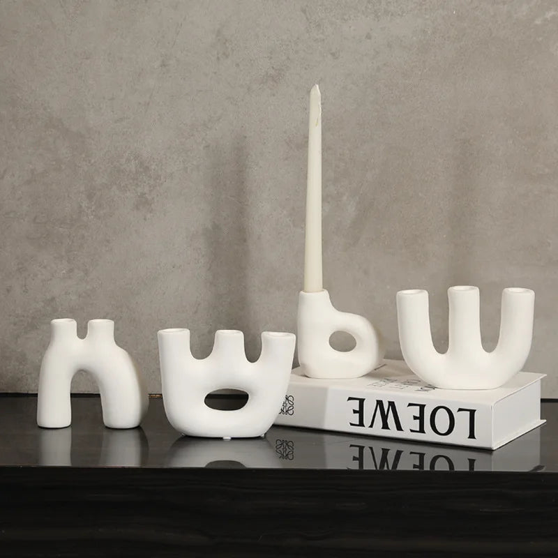 Reese Candle Holder collection - A modern display of ceramic candle holders in organic shapes, available in black and white colorways. The cool rounded shapes create a visually appealing design with four different variations. Elevate your space with these contemporary candle holders for a stylish and unique touch.