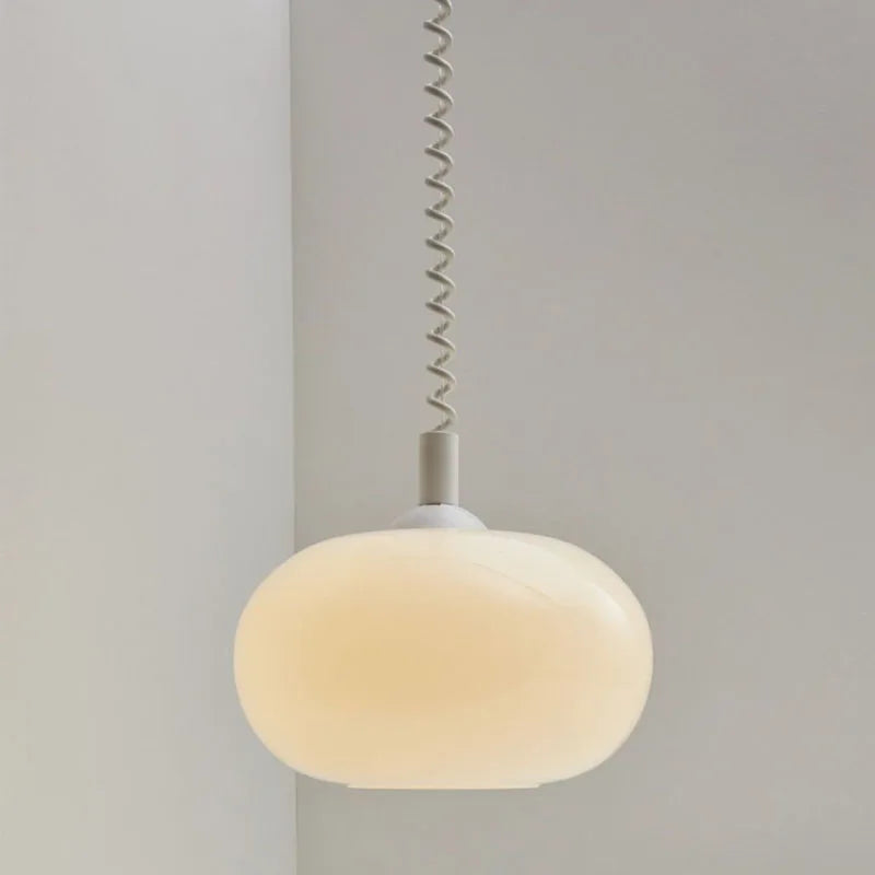 Modern Toz Pendant Light with hand-blown milkglass shade, colored coiled cord in primary colors, and adjustable length.