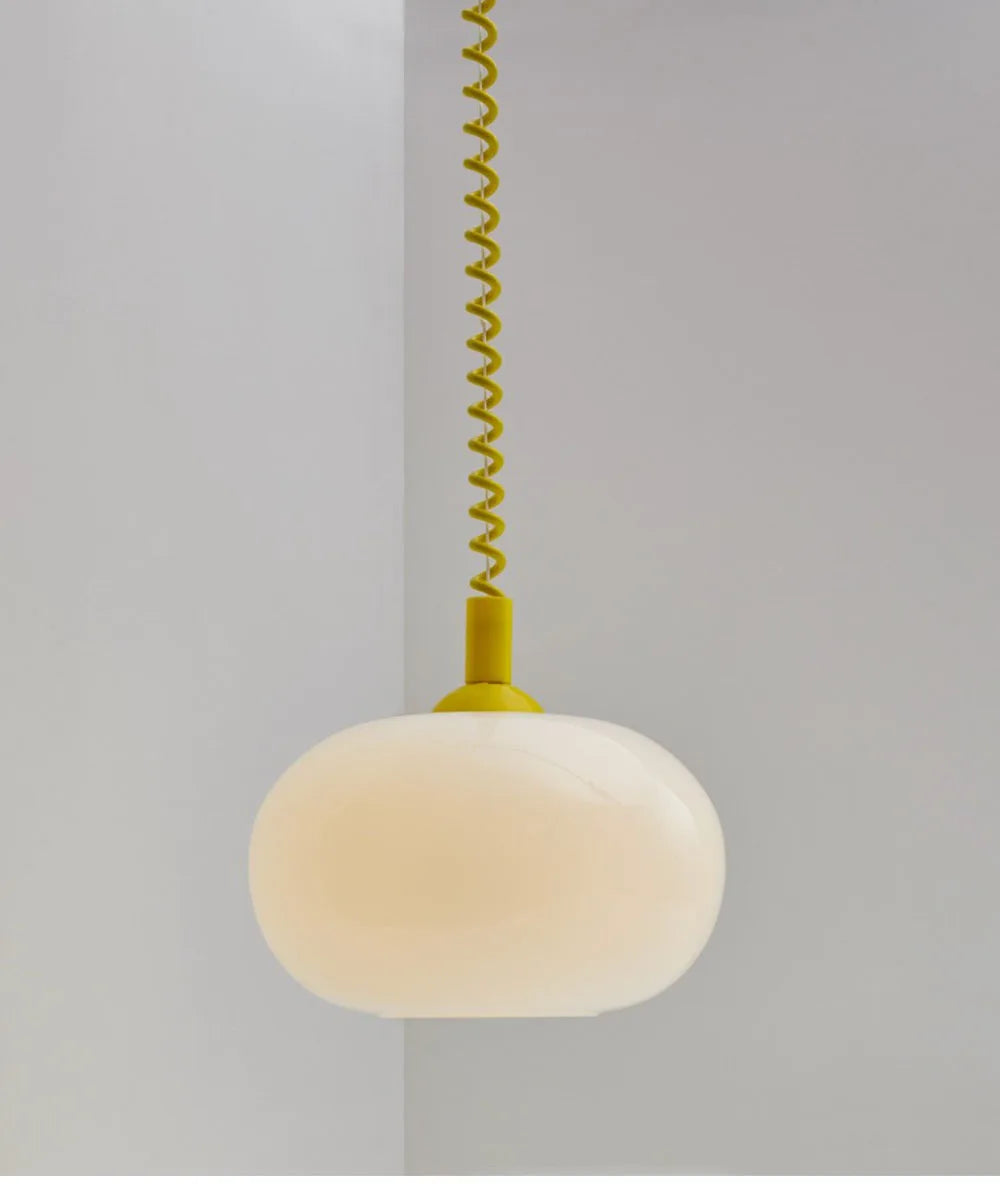 Modern Toz Pendant Light with hand-blown milkglass shade, colored coiled cord in primary colors, and adjustable length.