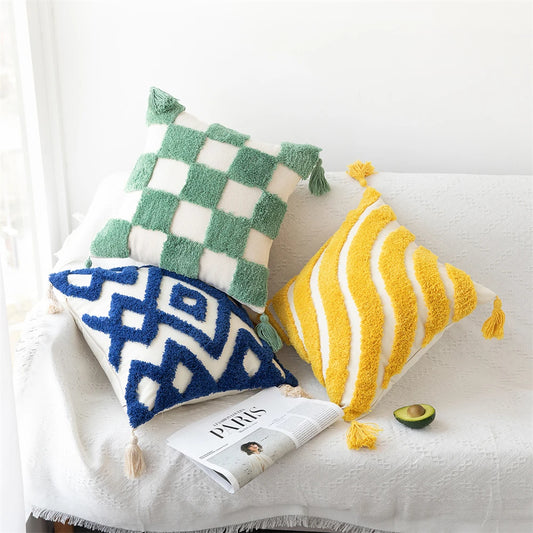 Photo displaying Zinnia Tufted Pillow Covers in vibrant colors with tufted details and charming tassels. Mix and match different patterns for a lively and sophisticated home décor. Inserts not included.