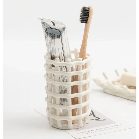 Image of the Qays Toothbrush Holder, a stylish and functional bathroom accessory made from high-quality ceramic. Features a handwoven ivory design and is versatile enough to hold toothbrushes, cosmetic brushes, and other small items. Ideal for home décor enthusiasts looking to add elegance and organization to their bathroom countertop.