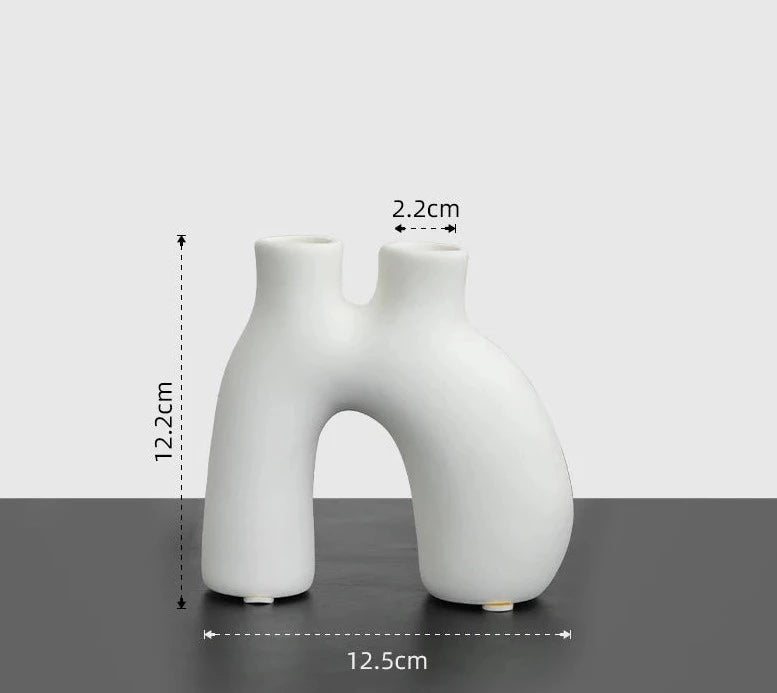 Reese Candle Holder collection - A modern display of ceramic candle holders in organic shapes, available in black and white colorways. The cool rounded shapes create a visually appealing design with four different variations. Elevate your space with these contemporary candle holders for a stylish and unique touch.