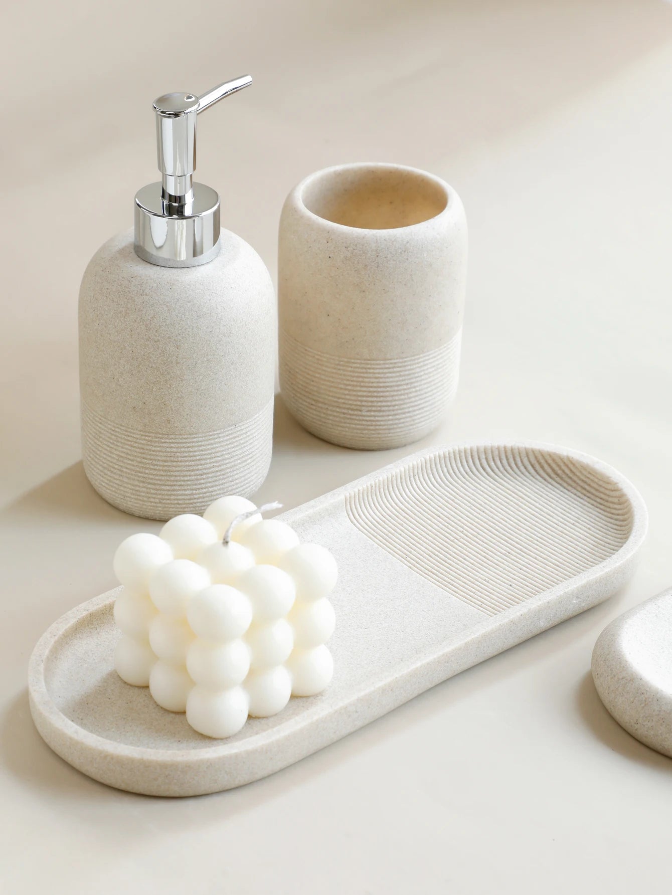 Inga Bath Set – five-piece resin bathroom set in neutral tones, including a tray, soap dish, dispenser, tumbler, and toothbrush holder for a chic, organized space.