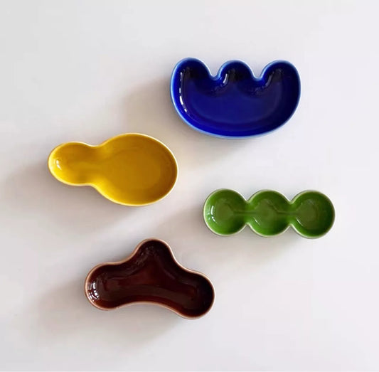 Handmade ceramic Rhett Dipping Dishes in bold vibrant colors, perfect for dipping and small bites. Four unique shapes provide versatility in presentation. Ideal for creating a mise en place. Shop now for artisanal charm in your dining experience.