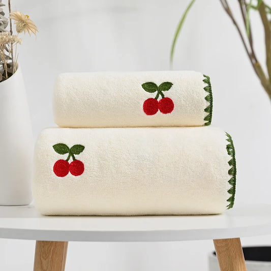 Effie Towel collection: bath and hand towels with embroidered fruit motifs, velvet feel, warm colorways, polyester and combed cotton.