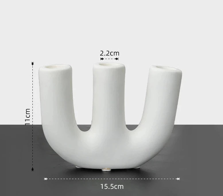 Reese Candle Holder collection - A modern display of ceramic candle holders in organic shapes, available in black and white colorways. The cool rounded shapes create a visually appealing design with four different variations. Elevate your space with these contemporary candle holders for a stylish and unique touch.