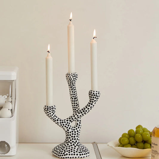 White ceramic Dotty Candle Holder with black polka dots, designed to hold three candles. A whimsical and eclectic decor piece, perfect for adding charm and warmth to any space.