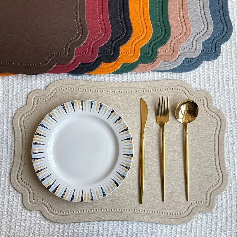 Zachary Placemat made from faux leather, featuring a sleek embossed design with curved edge detailing. The placemat measures 45 x 30 cm and is crafted from waterproof, oilproof PVC with a non-slip surface. Available in various colorways, it is ideal for home décor enthusiasts seeking both style and practicality for their dining table.