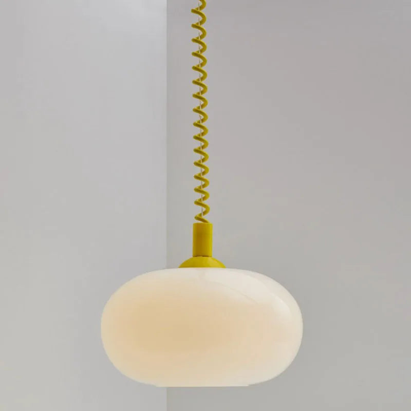 Modern Toz Pendant Light with hand-blown milkglass shade, colored coiled cord in primary colors, and adjustable length.