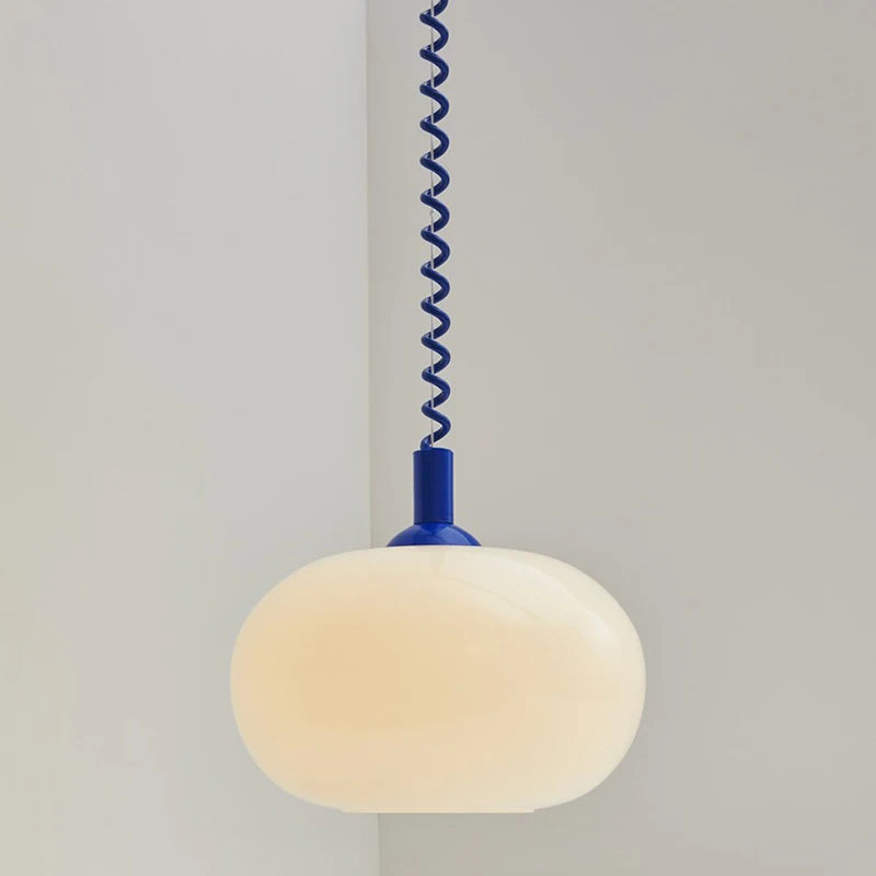 Modern Toz Pendant Light with hand-blown milkglass shade, colored coiled cord in primary colors, and adjustable length.